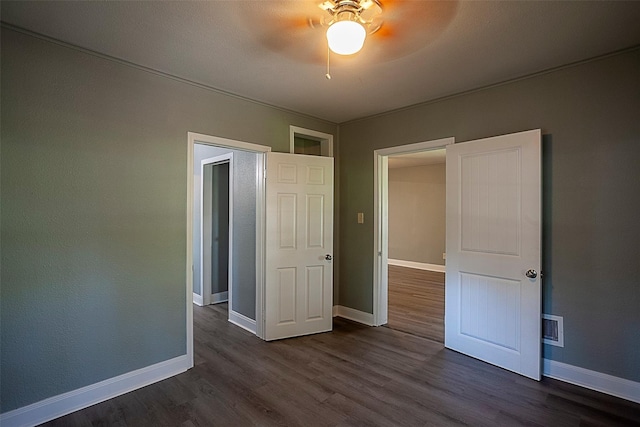 unfurnished bedroom featuring ceiling fan and dark hardwood / wood-style floors