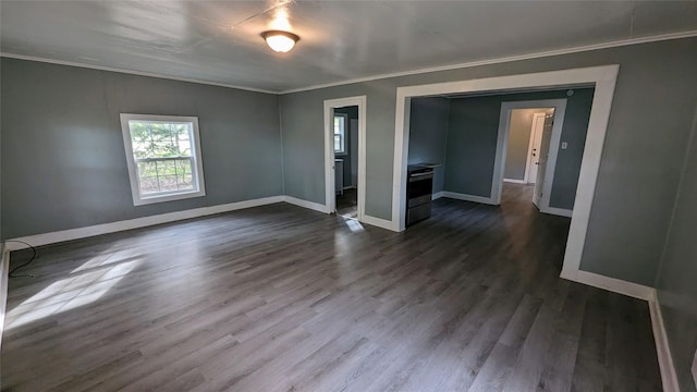 unfurnished room featuring ornamental molding, baseboards, and wood finished floors