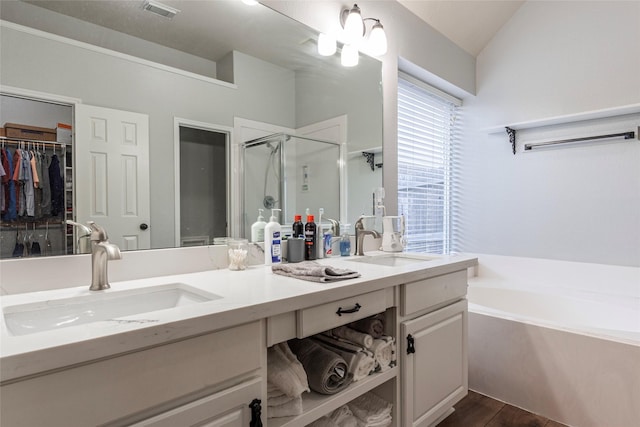 bathroom featuring hardwood / wood-style flooring, lofted ceiling, vanity, and independent shower and bath