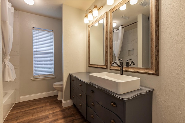 full bathroom with shower / tub combo, vanity, toilet, and hardwood / wood-style floors