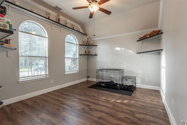 interior space with dark wood-type flooring, ceiling fan, lofted ceiling, and crown molding