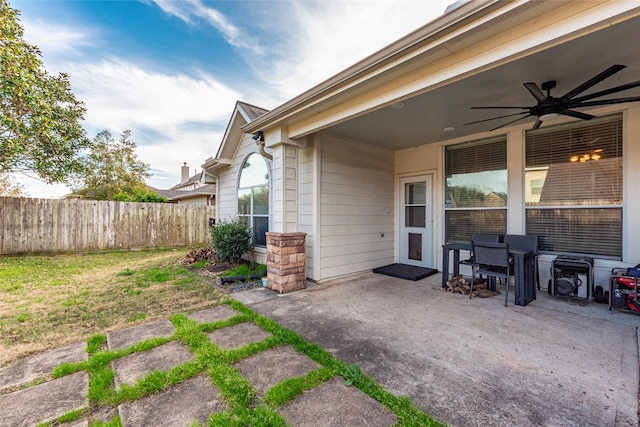 doorway to property with a yard, a patio area, and ceiling fan