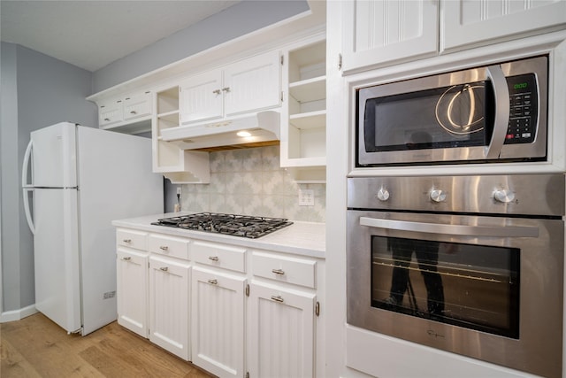 kitchen featuring backsplash, stainless steel appliances, light hardwood / wood-style floors, and white cabinets