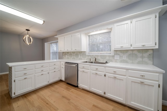 kitchen with sink, decorative light fixtures, stainless steel dishwasher, kitchen peninsula, and white cabinets