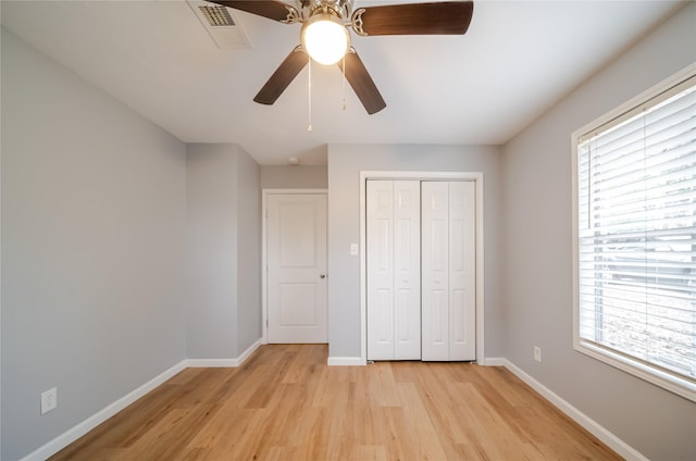 unfurnished bedroom with ceiling fan, light hardwood / wood-style floors, and a closet