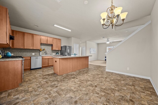 kitchen with sink, tasteful backsplash, a kitchen island, pendant lighting, and stainless steel appliances