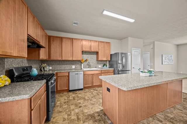 kitchen with tasteful backsplash, appliances with stainless steel finishes, a center island, and sink