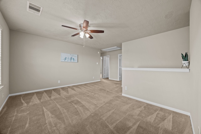 carpeted spare room with ceiling fan and a textured ceiling