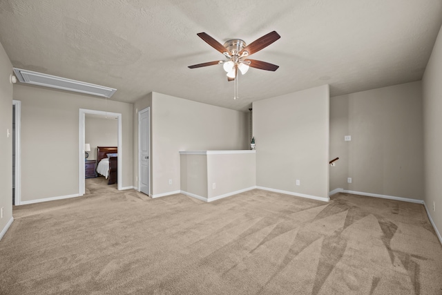 spare room with light colored carpet and a textured ceiling