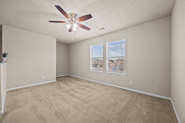 spare room featuring baseboards, visible vents, a textured ceiling, and light colored carpet