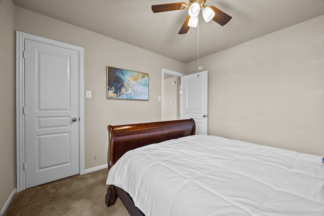 carpeted bedroom with ceiling fan and baseboards