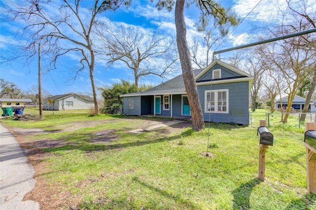 view of front of home with a front lawn and fence