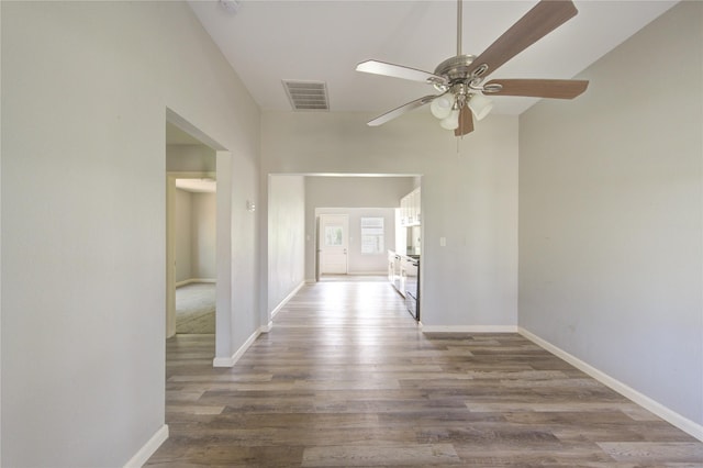 unfurnished room featuring a ceiling fan, baseboards, visible vents, and wood finished floors