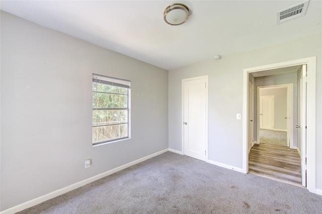 unfurnished bedroom with carpet floors, baseboards, and visible vents