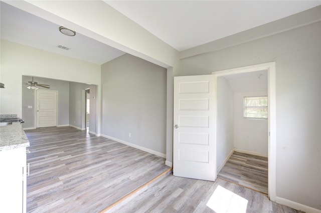 empty room featuring light wood finished floors, visible vents, and baseboards