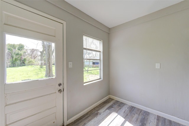 doorway to outside with light wood finished floors and baseboards