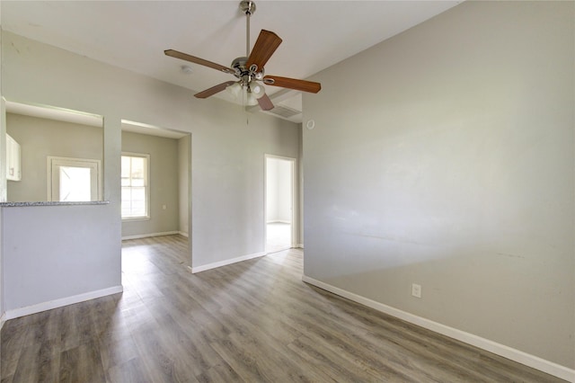 unfurnished room with a ceiling fan, baseboards, and wood finished floors