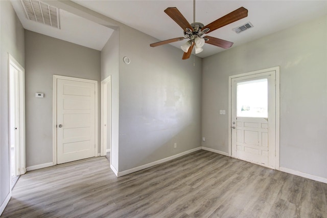 foyer with light wood-type flooring, visible vents, and baseboards