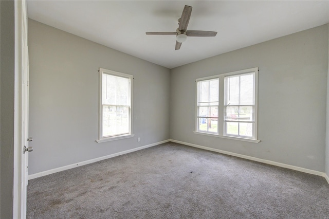 empty room with a healthy amount of sunlight, ceiling fan, baseboards, and carpet flooring