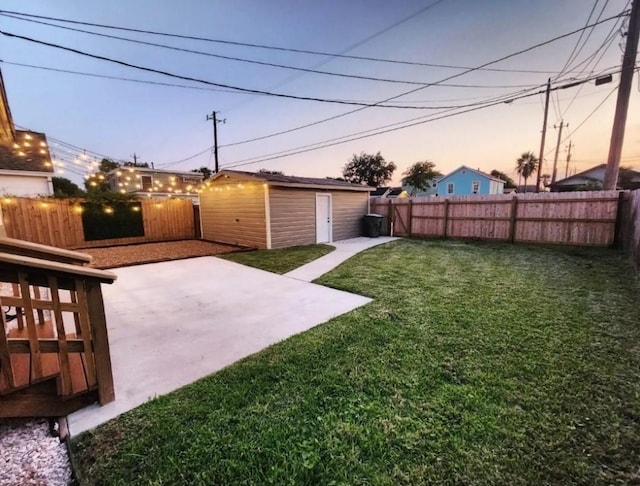 yard at dusk with a storage shed and a patio area