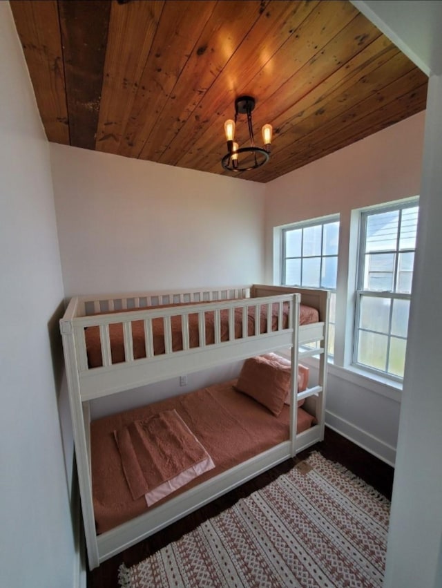 bedroom featuring an inviting chandelier and wooden ceiling