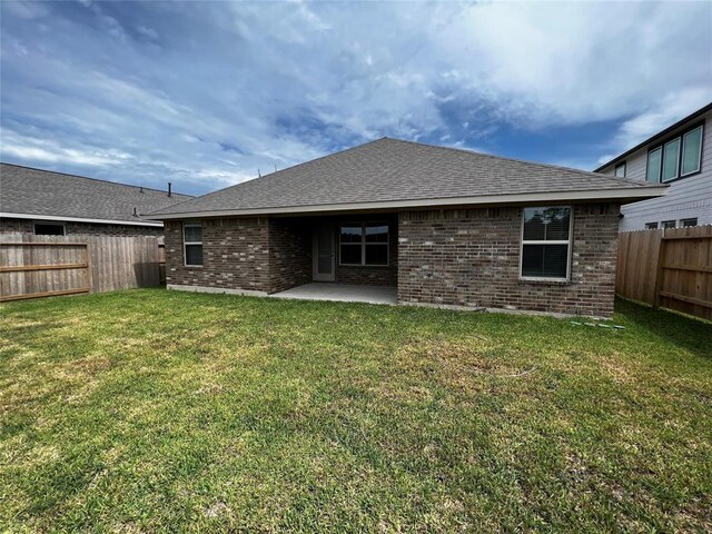 back of house with a yard and a patio