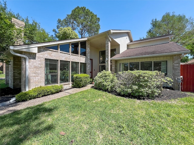 rear view of house featuring a yard