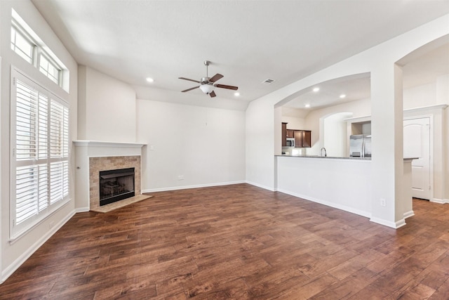 unfurnished living room with plenty of natural light, dark wood-type flooring, and a fireplace