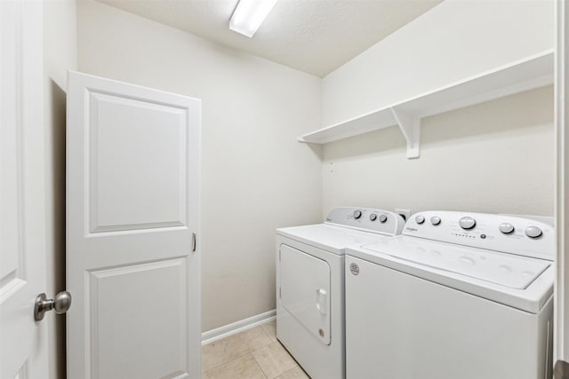 laundry area with separate washer and dryer and light tile patterned floors