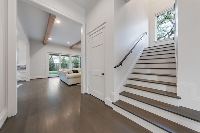 stairway featuring crown molding, beam ceiling, and hardwood / wood-style floors