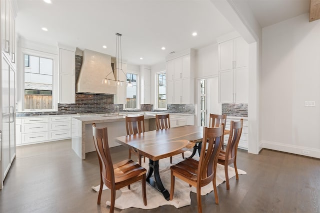 dining room with dark hardwood / wood-style floors, sink, and beam ceiling