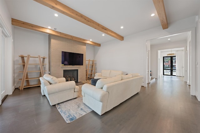 living room featuring dark wood-type flooring, a fireplace, beam ceiling, and french doors