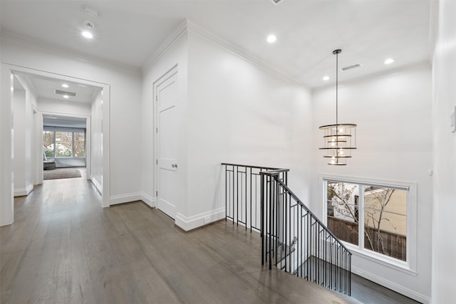 hall featuring hardwood / wood-style flooring, ornamental molding, and a chandelier