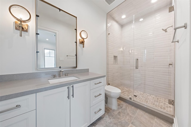 bathroom with walk in shower, vanity, and toilet