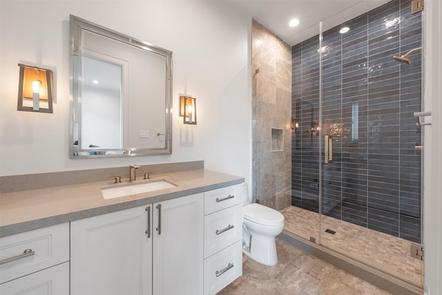 bathroom featuring vanity, a shower with shower door, and toilet