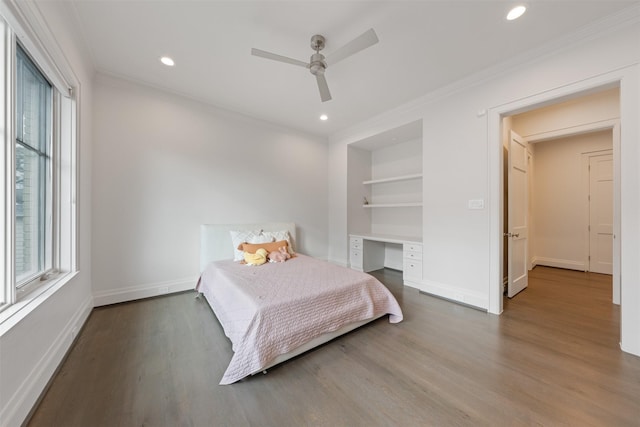 bedroom with ceiling fan, ornamental molding, built in desk, and hardwood / wood-style floors