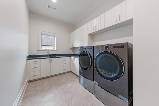 laundry area featuring cabinets, sink, and washer and clothes dryer