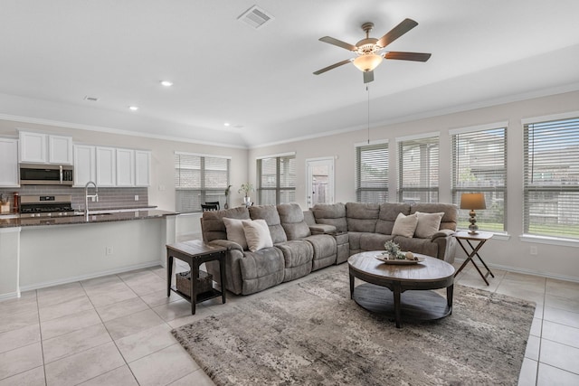 living room featuring ceiling fan, ornamental molding, and light tile patterned floors