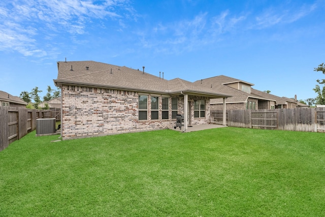 rear view of house featuring a lawn, central air condition unit, and a patio area