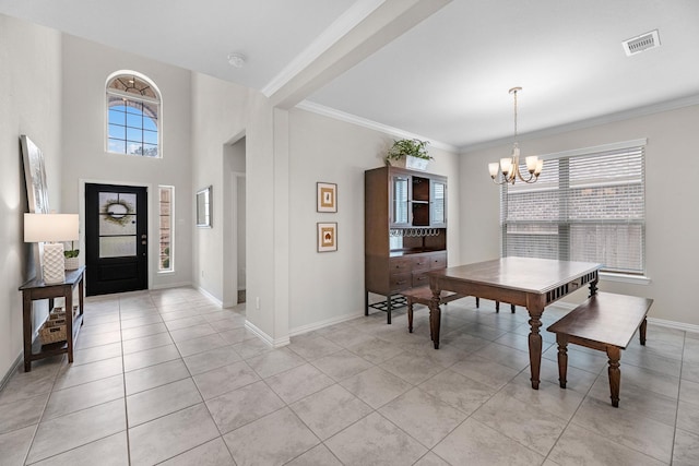 tiled foyer with ornamental molding and an inviting chandelier