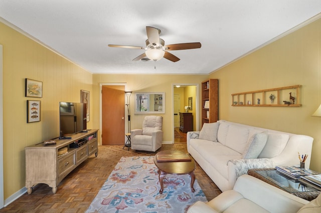 living room featuring dark parquet flooring, crown molding, ceiling fan, and wood walls