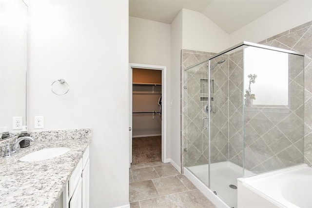 bathroom featuring vanity, vaulted ceiling, and separate shower and tub