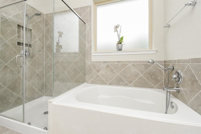 bathroom featuring shower with separate bathtub