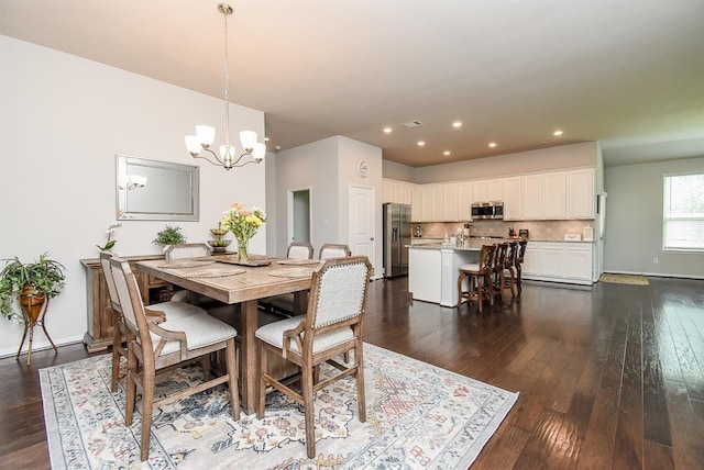 dining area with a notable chandelier and dark hardwood / wood-style flooring