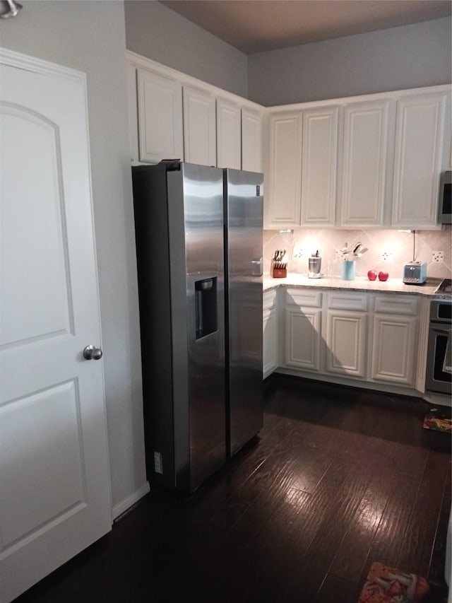 kitchen with white cabinetry, appliances with stainless steel finishes, dark hardwood / wood-style floors, and decorative backsplash