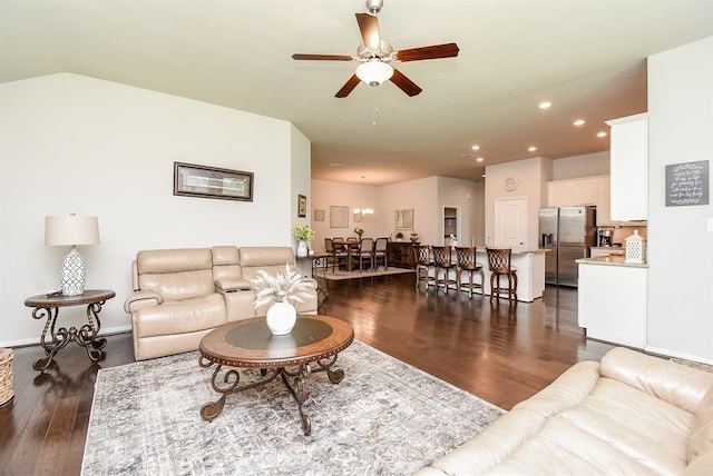 living room with ceiling fan, dark hardwood / wood-style floors, and vaulted ceiling