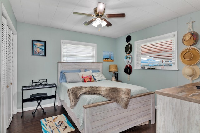 bedroom featuring ceiling fan, a closet, dark hardwood / wood-style floors, and multiple windows