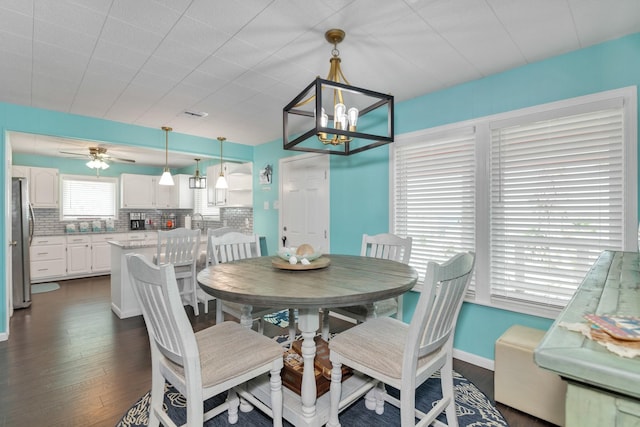 dining space with dark hardwood / wood-style floors and ceiling fan with notable chandelier