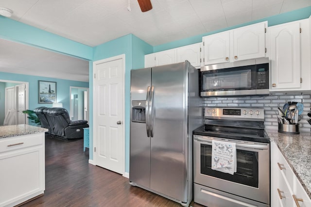 kitchen featuring tasteful backsplash, dark hardwood / wood-style flooring, stainless steel appliances, light stone countertops, and white cabinets