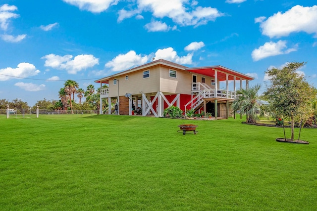 back of house featuring a lawn and a fire pit